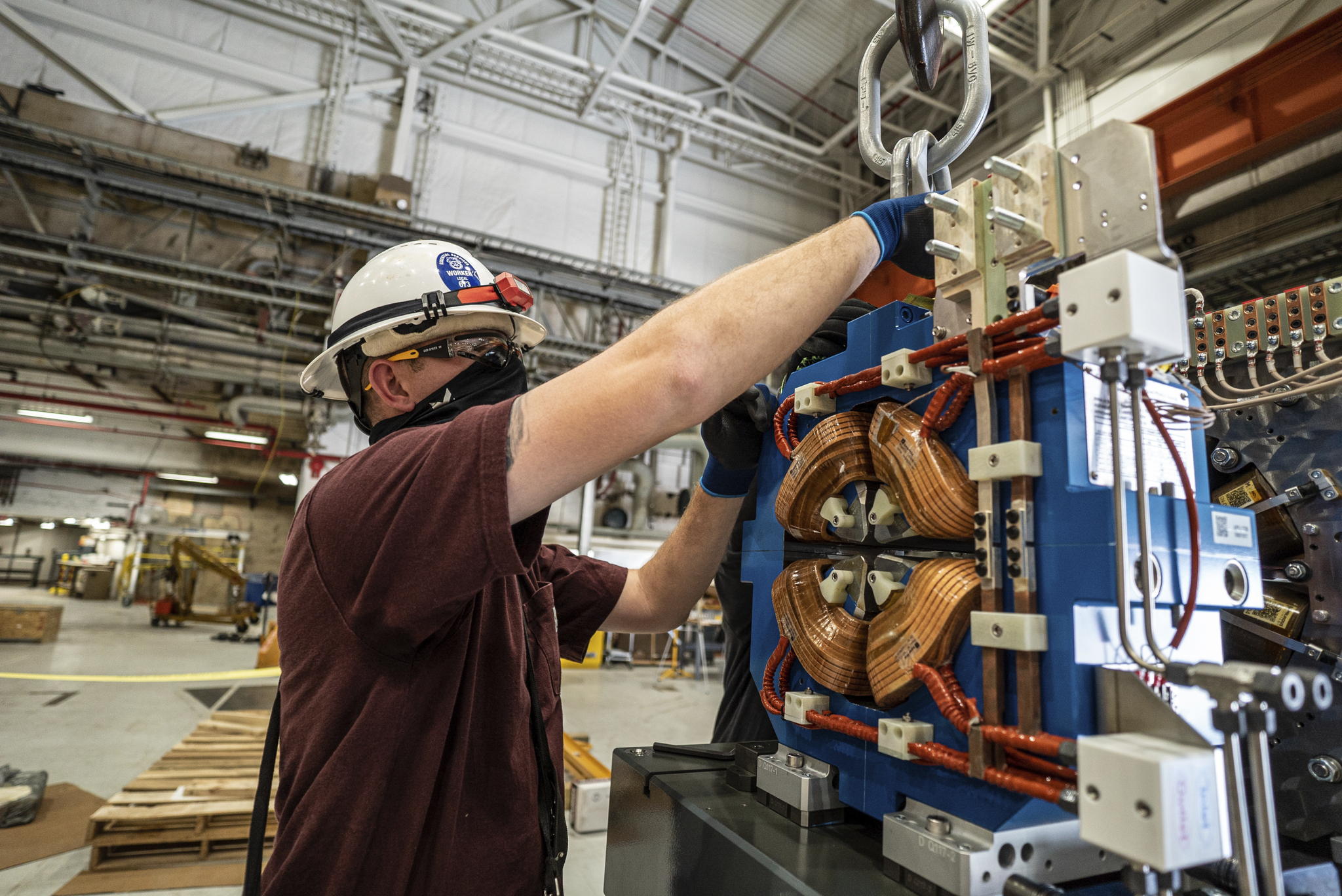 Driver/Rigger Ryan Roberts disassembles connections on a quadrupole magnet during the first practice assembly of the first magnet module that will be used in the upgrade of the Advanced Photon Source’s storage ring. (Image by JJ Starr/Argonne National Laboratory.) 